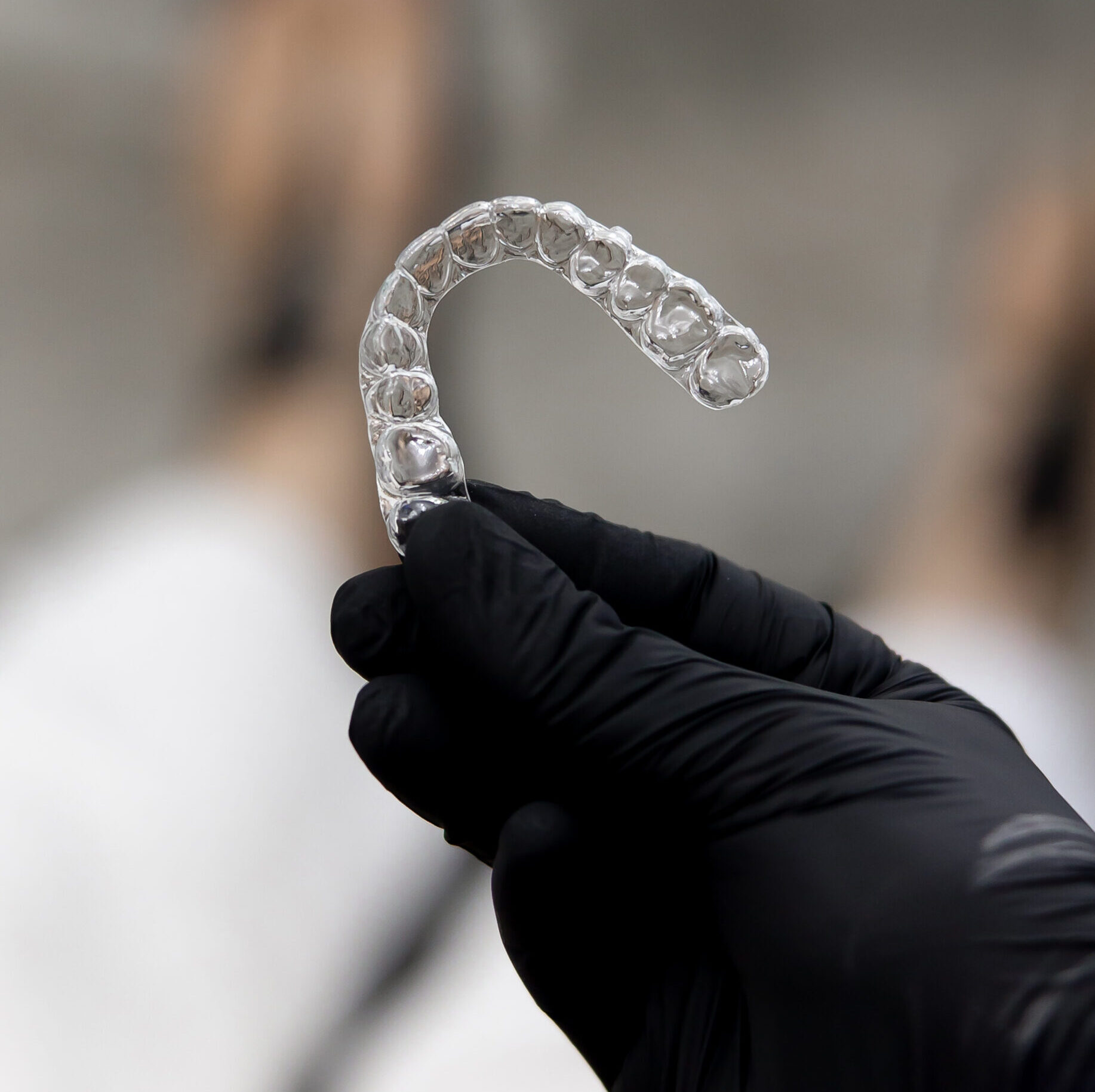 A demonstration of aligners held in hands, showcasing their clear design and effectiveness for teeth straightening. This scene highlights the innovative approach to achieving a confident smile.